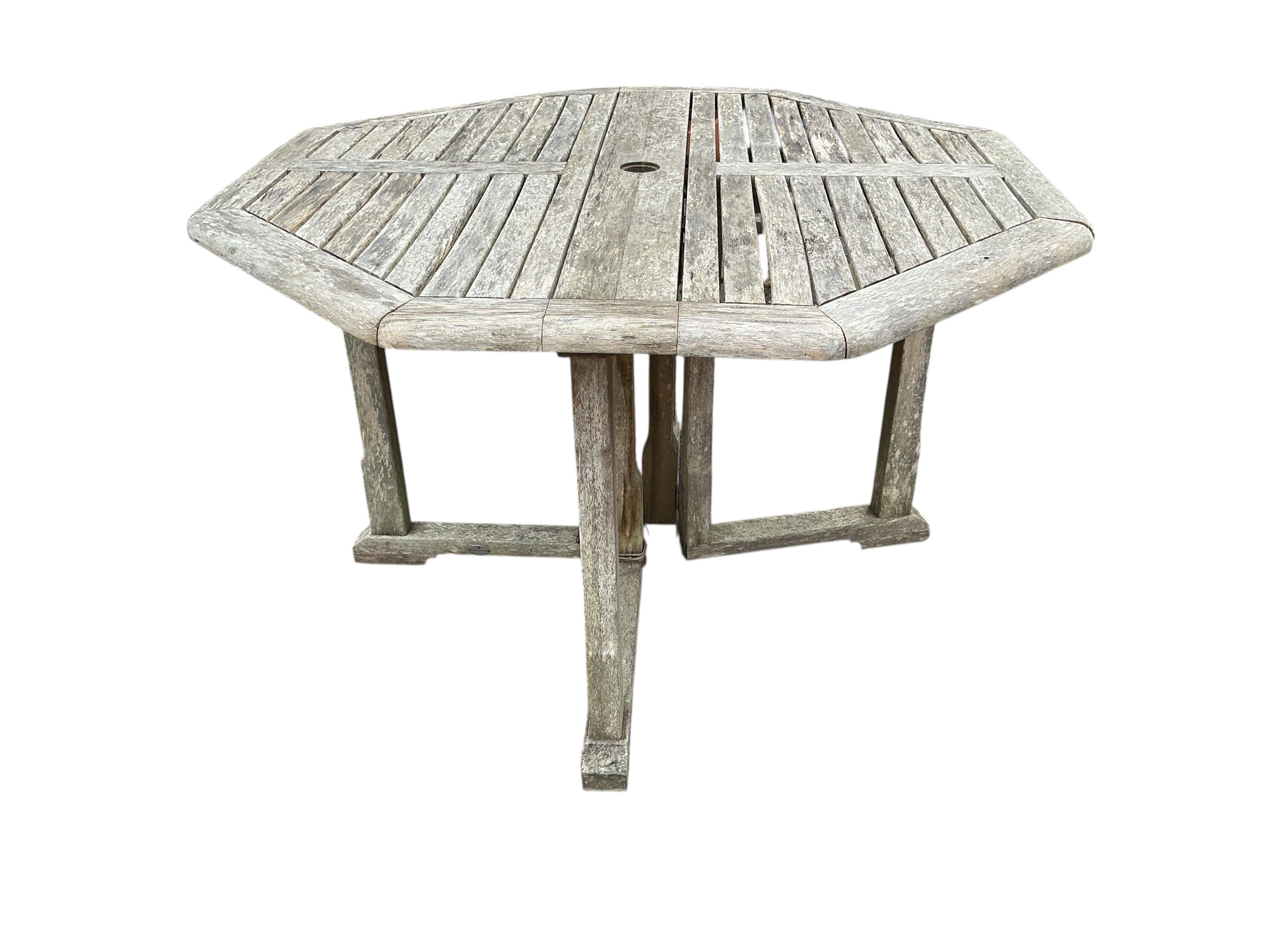 A weathered teak octagonal folding garden table, width 120cm, height 74cm